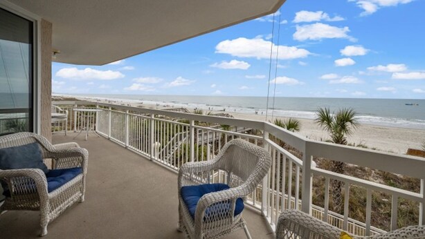 A balcony with wicker chairs and a view of the beach. - Crescent Shores N 201-4BR Oceanfront Condo (North Myrtle Beach)