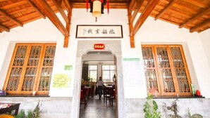 A traditional building with a wooden roof and a sign above the entrance. - Huiyun Inn (Jing County)
