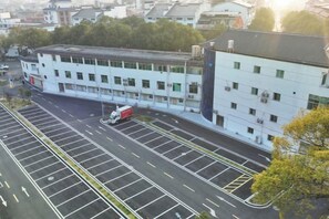 A multi-story building with a parking lot in front. - Hengyang Wangyuelou Homestay (Mount Heng Scenic Area Nanyue Grand Temple) (Hengyang)