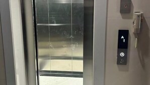 Un ascensor con un panel de control que muestra una flecha hacia arriba y un botón.
