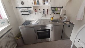 Una cocina moderna con electrodomésticos de acero inoxidable, un lavamanos y un ventanal con vistas.