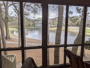 Una habitación con un ventanal que da a un lago y un campo de golf.