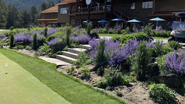 Un grand chalet doté d’une horloge, d’un espace extérieur aménagé et d’un parcours de golf.