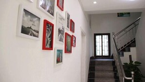 Un escalier avec une rampe métallique menant à un palier doté d’une porte.