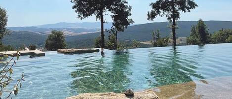 Una piscina a sfioro, lettini