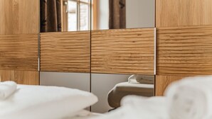 Ein hölzerner Kopfseitenverkleidung mit Spiegel und Toilette in einem Badezimmer.
