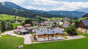 Ein Dorf mit traditionellen Holzhäusern, einer Kirche und einem Berg im Hintergrund.