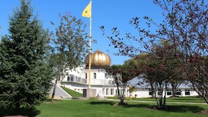 Un bâtiment surmonté d’un dôme doré et d’un mât portant un drapeau jaune.