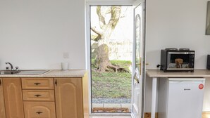 A compact kitchen with wooden cabinets, a sink, a toaster, and a refrigerator.