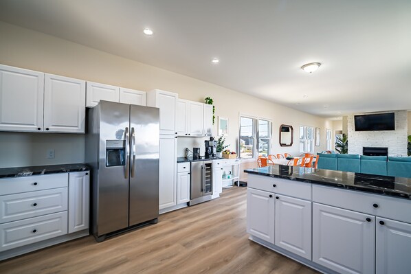 A modern kitchen with white cabinets, a stainless steel refrigerator, and a built-in oven. - Lagoon Home with Dock + Bar -Near Calm, Kid-Friendly Beach (Little Egg Harbor Township)