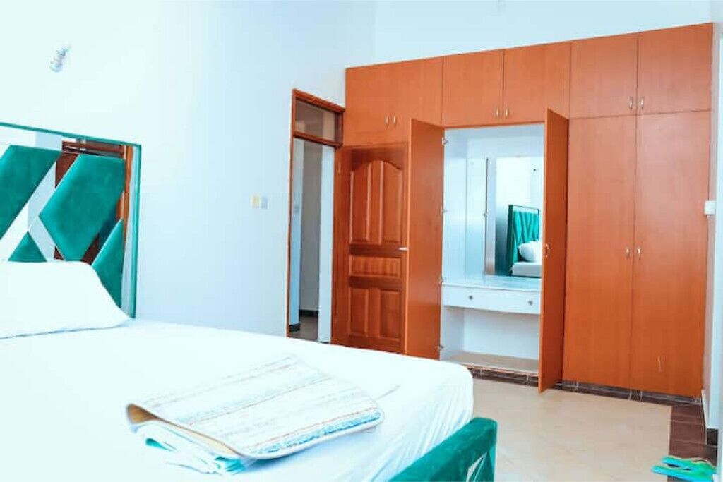 Une chambre à coucher avec un lit, une armoire en bois et un miroir.