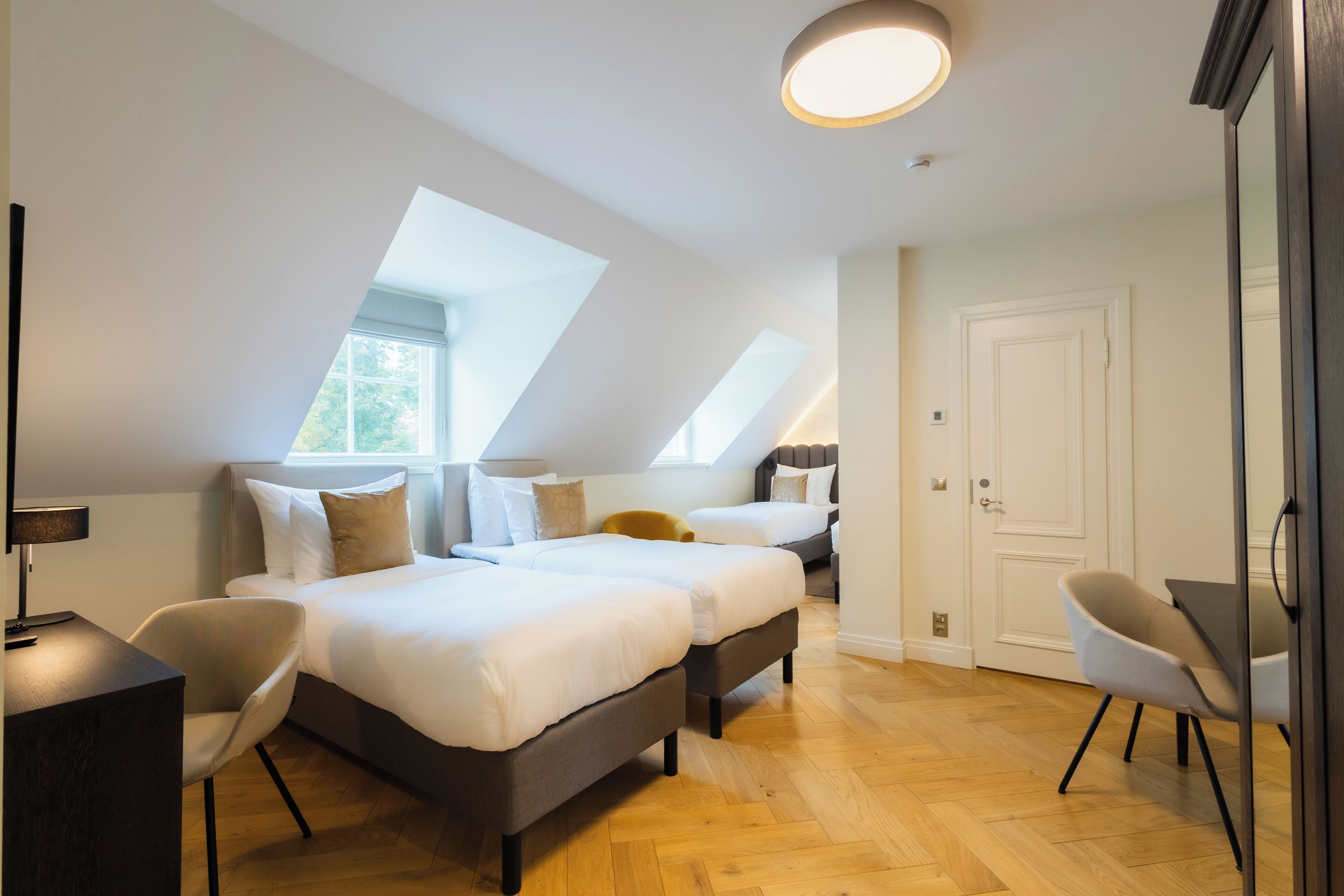 Un dormitorio moderno con dos camas, un escritorio y una silla.