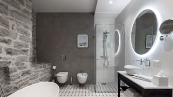 A modern bathroom with a freestanding bathtub, a glass-enclosed shower, and a vanity with a large mirror.