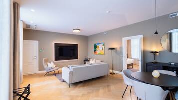 A modern living room with a sofa, a dining table, and a TV.