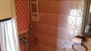 A bathroom with a shower, a toilet, and a sink.