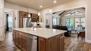 A spacious kitchen with wooden cabinets, stainless steel appliances, and pendant lighting. - Outdoor Sanctuary/Lake View/Hot tub & Game Room! (Canyon Lake)