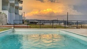 A swimming pool with a modern building in the background.