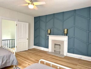 Cozy retreat with a geometric patterned wall, a comfortable bed, and a fireplace.