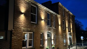 A brick building with multiple windows and doors, some illuminated. - Winckley Square Residences (Preston)