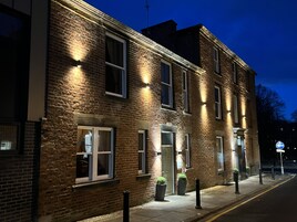 Un edificio de ladrillo con varias ventanas y puertas, algunas iluminadas.
