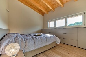 Une chambre à coucher avec un lit, une fenêtre et un plafond en bois.