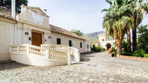 A historic building with a white facade, a stone-paved courtyard, and a palm tree. - Allegroitalia Torre Artale Palermo (Trabia)