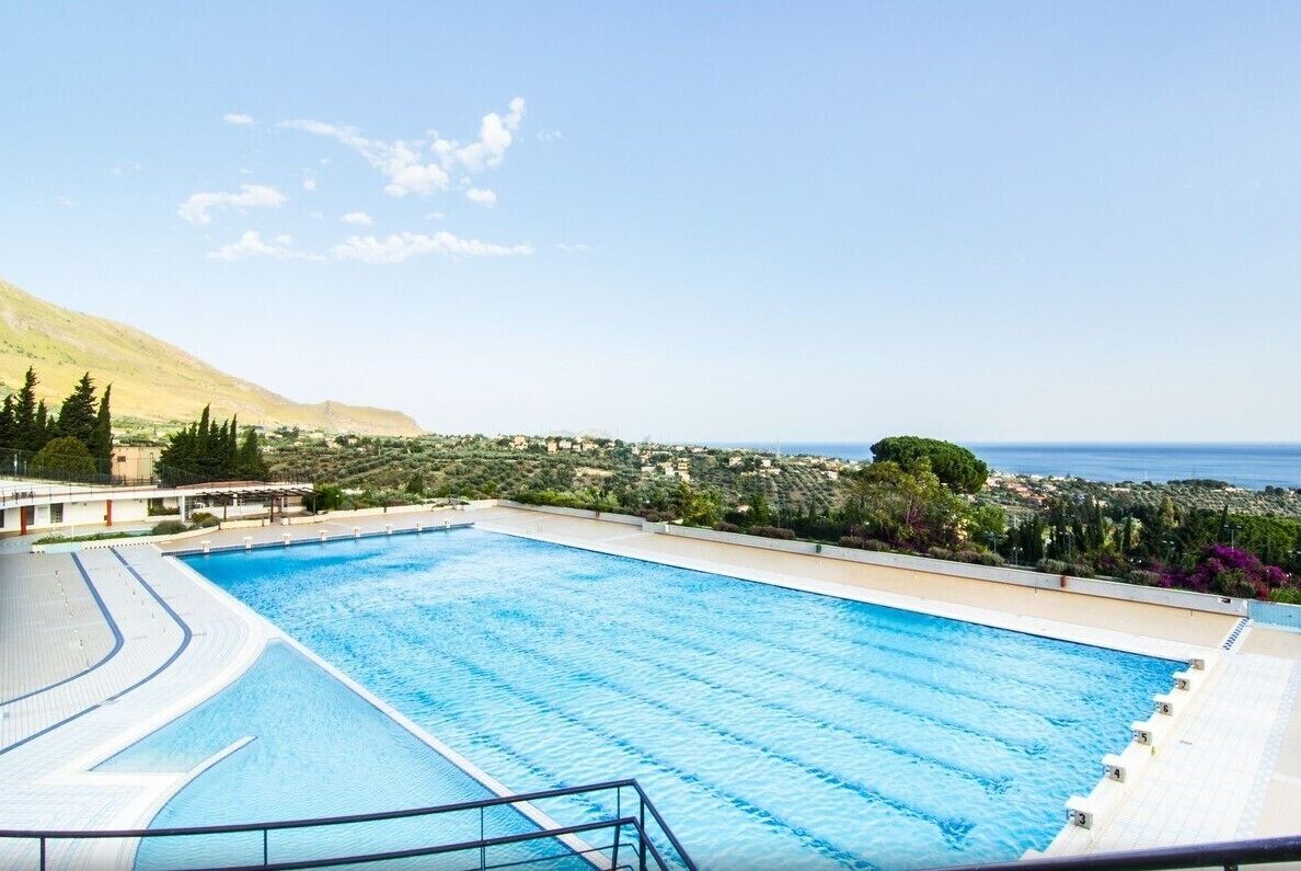 Una piscina al aire libre de temporada, sombrillas