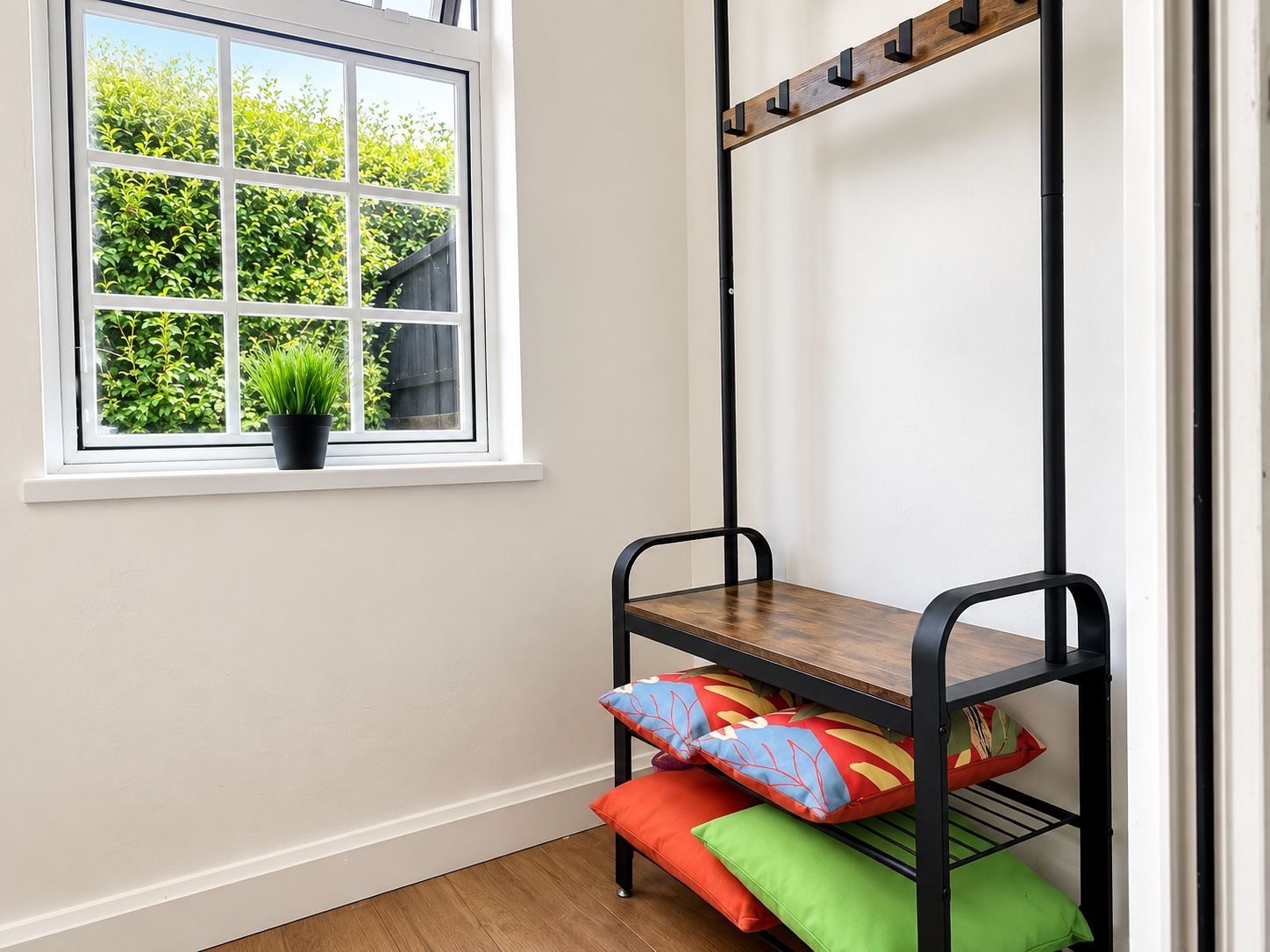 A bunk bed with a wooden top and metal frame, a window with a view of greenery, and a potted plant on the windowsill.