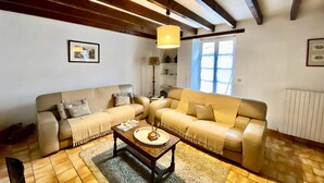Ein Wohnzimmer mit zwei Sofas, einem Couchtisch und einer Lampe.