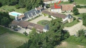 Luftaufnahme eines Wohngebiets mit mehreren Gebäuden, einem Schwimmbad und umliegender Grünfläche.