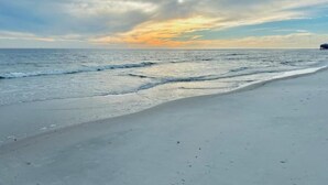 Una playa con mar tranquilo y cielo nublado.