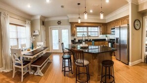 Una cocina amplia con una isla central, armarios de madera y electrodomésticos de acero inoxidable.