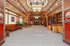 Een klassiek interieur met houten balken, een centraal zitgedeelte en een bar.