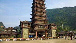 A traditional multi-tiered pagoda-style building with a large entrance and a surrounding courtyard. - Zhangjiajie Wulingju Inn (Wulingyuan Scenic Area) (Zhangjiajie)