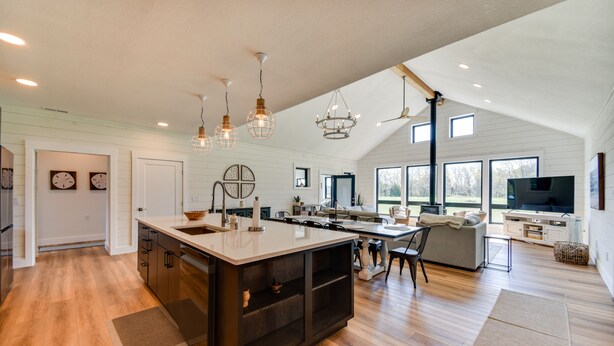 A spacious kitchen with a large island, modern pendant lights, and a dining area with a sofa and chairs. - Stunning Chesapeake Bay Farmhouse w/ Dock & Kayaks (Machipongo)