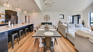 A modern kitchen with a central island, bar stools, and pendant lighting. - Stunning Chesapeake Bay Farmhouse w/ Dock & Kayaks (Machipongo)