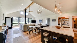 A spacious kitchen with a large island, wooden flooring, and modern lighting fixtures. - Stunning Chesapeake Bay Farmhouse w/ Dock & Kayaks (Machipongo)
