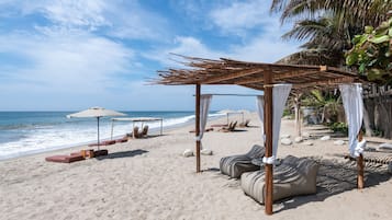 Een privéstrand, wit zand, parasols, strandlakens