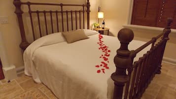 A neatly made bed with a wooden headboard, a bedside table with a lamp, and a decorative item on the nightstand.