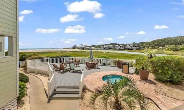 Um terraço com móveis para área externa, piscina e vista para a praia e o oceano.