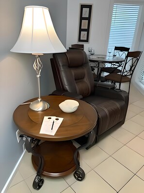 Relax in a cozy space with a leather sofa, round table, and framed artwork.