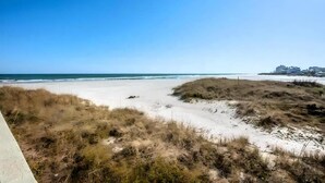 En strand med klitter og en klar blå himmel.