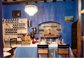 Enjoy a warm dining experience with a beautifully set table, ornate chandelier, and wine selection.