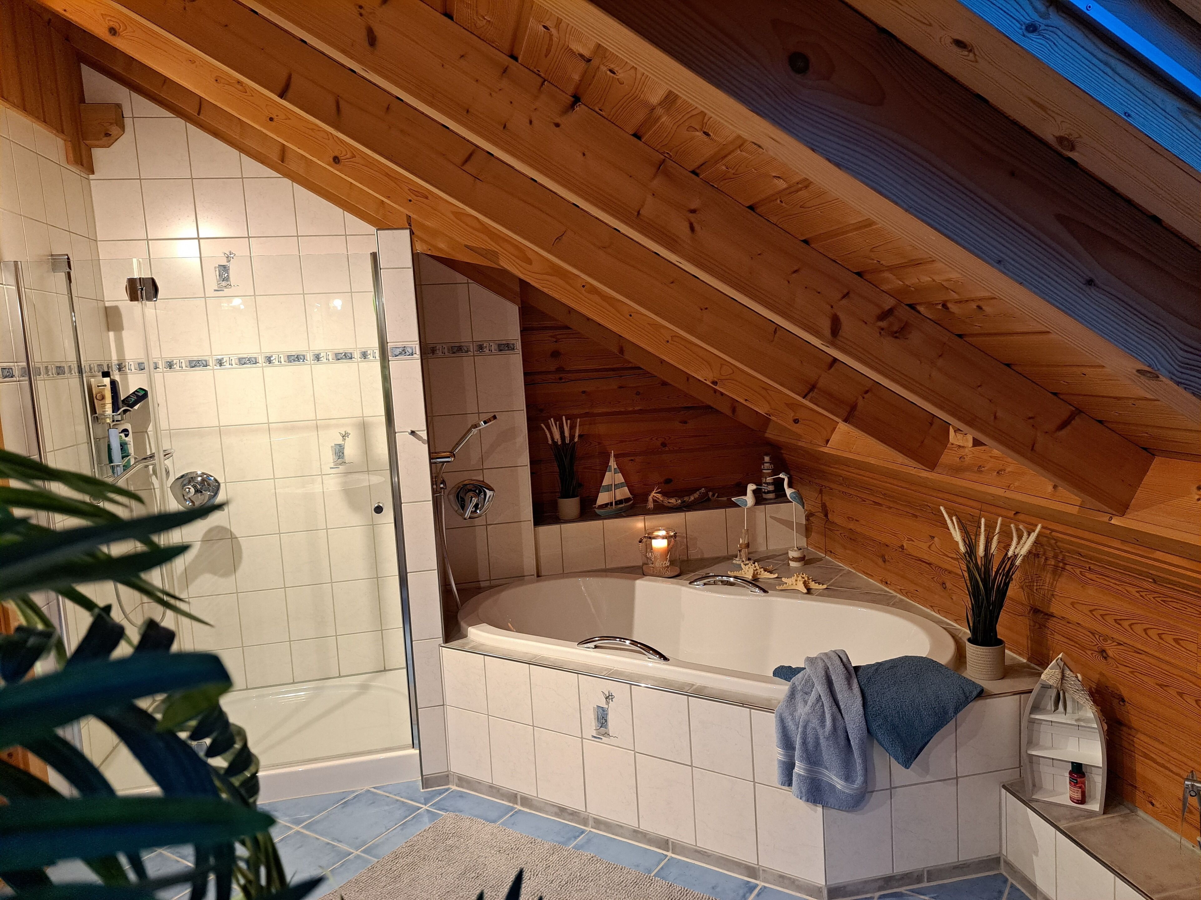 Une salle de bain avec une baignoire, une douche et un plafond en bois.