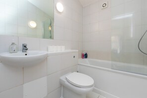 Une salle de bain équipée d’un lavabo, d’un miroir, de toilettes et d’une douche.