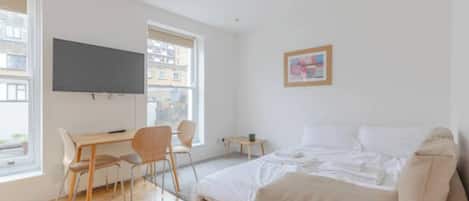 Une chambre à coucher moderne avec un lit, un bureau et une chaise.