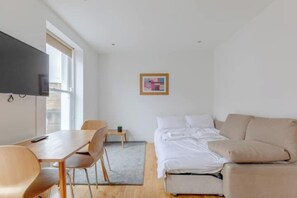 Ein modernes Zimmer mit Bett, Schreibtisch und Stuhl.
