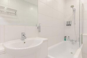 Une salle de bain avec un lavabo, une baignoire et une douche.