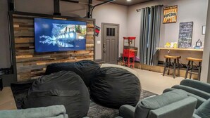 Ein moderner Loungebereich mit Flachbildfernseher, Sitzsäcken und einer Snackbar.