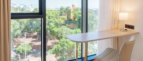A modern room with a large window, a desk, and a chair.